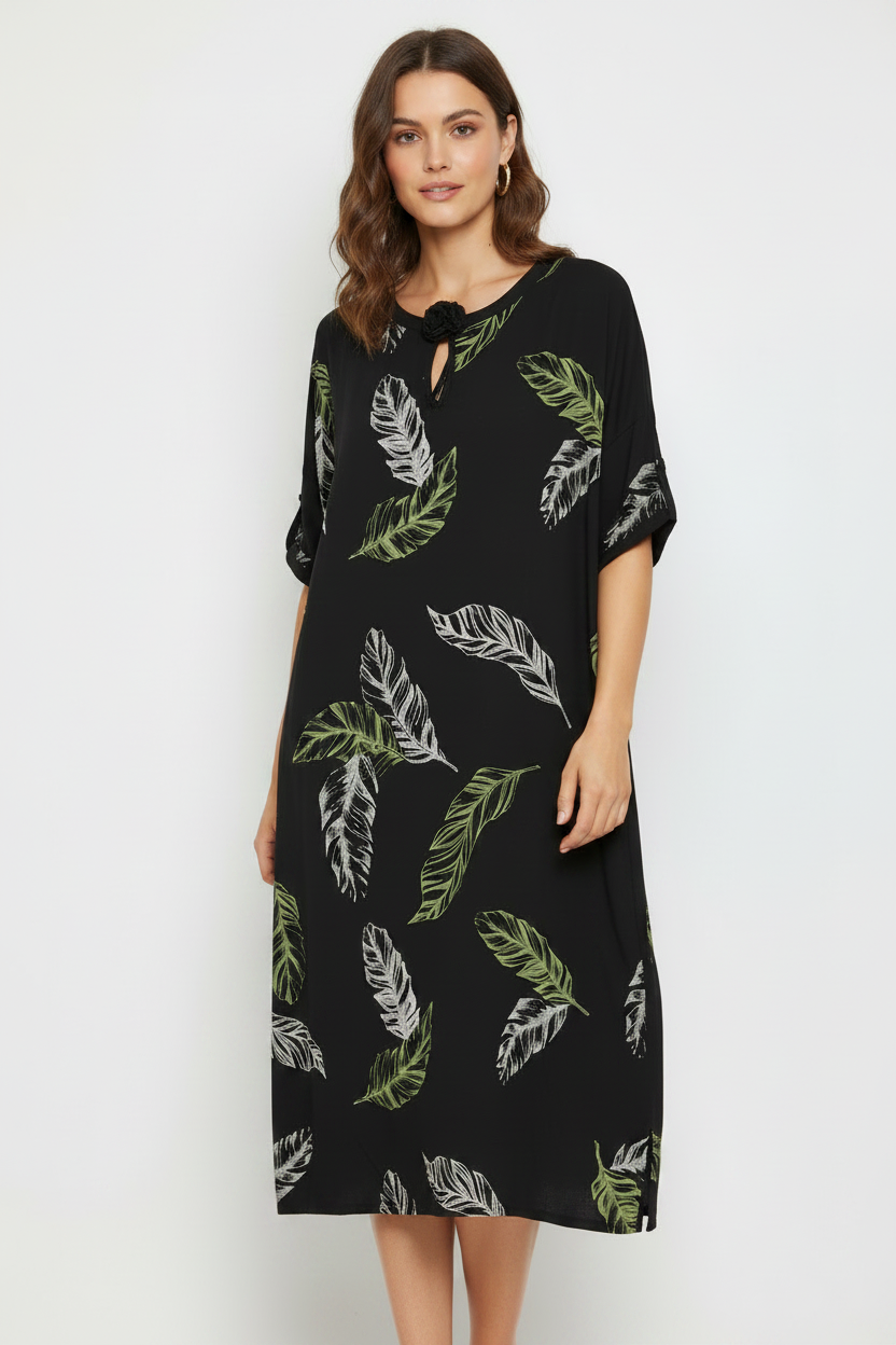 Model wearing black tropical leaf dress with tassel neckline